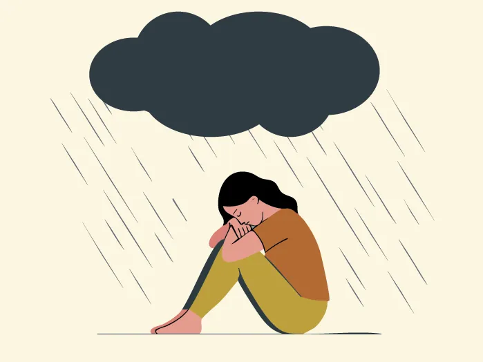 Une jeune fille assise au sol, la tête sur les genoux, sous un gros nuage noir dont tombe de la pluie fine.