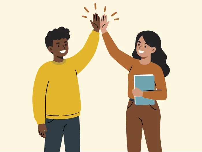 Un jeune homme et une jeune femme souriants se tapent dans la main (high-five).